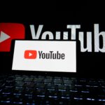 Telefon mobil cu aplicația YouTube deschisă și funcția de redare muzică în fundal activată