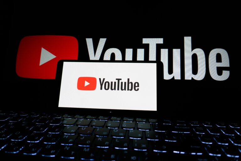 Telefon mobil cu aplicația YouTube deschisă și funcția de redare muzică în fundal activată