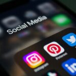 Smartphone cu iconițe ale aplicațiilor de social media afișate pe ecran.
