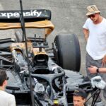 Scenă dintr-un film aflat în producție despre Formula 1, prezentând mașini de curse și atmosfera din spatele culiselor.