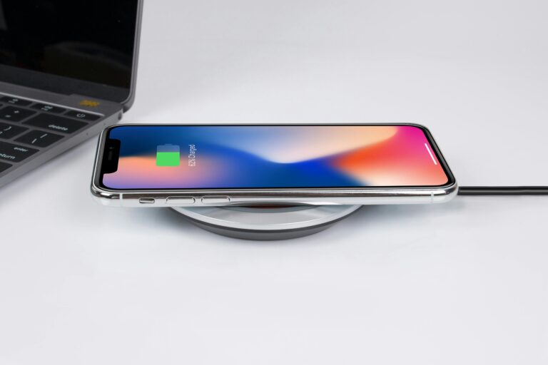 Dispozitiv de încărcare wireless pentru telefoane moderne, ilustrat cu un telefon plasat pe suportul de încărcare.