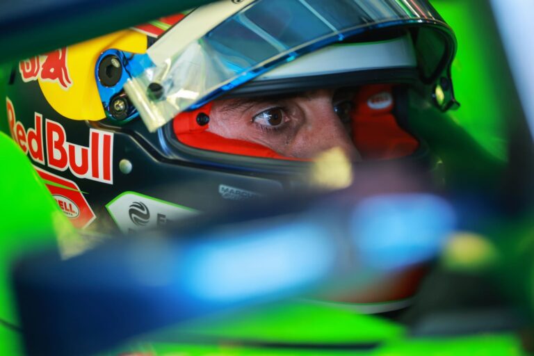 Pilot Red Bull purtând cască colorată în albastru, roșu și galben, specifică echipei, în timpul unei curse sau sesiuni de teste în Formula E.