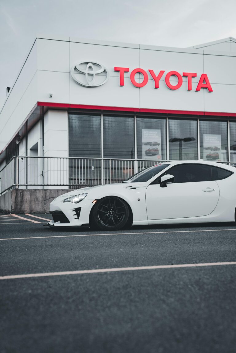 Logo-ul Toyota afișat pe un fundal neutru, ilustrând designul modern cu trei elipse care se intersectează, simbolizând istoria și valorile brandului.