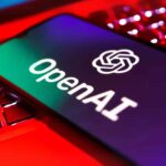 Logo OpenAI pe ecranul unui telefon mobil, reprezentând tehnologia de inteligență artificială accesibilă pe dispozitive portabile.