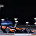 Mașină de Formula 1 McLaren pe circuitul din Bahrain în timpul testelor din 2026, cu echipa Red Bull în evidență.