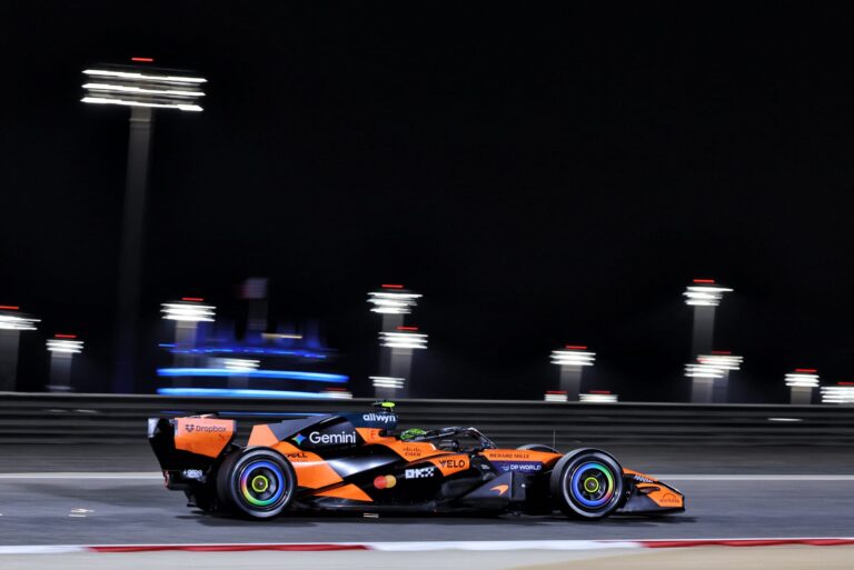 Mașină de Formula 1 McLaren pe circuitul din Bahrain în timpul testelor din 2026, cu echipa Red Bull în evidență.