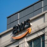 Logo AWS pe o clădire modernă, simbolizând servicii cloud și tehnologie avansată.