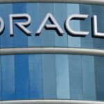 Logo-ul companiei Oracle pe fațada unei clădiri moderne cu geamuri albastre.