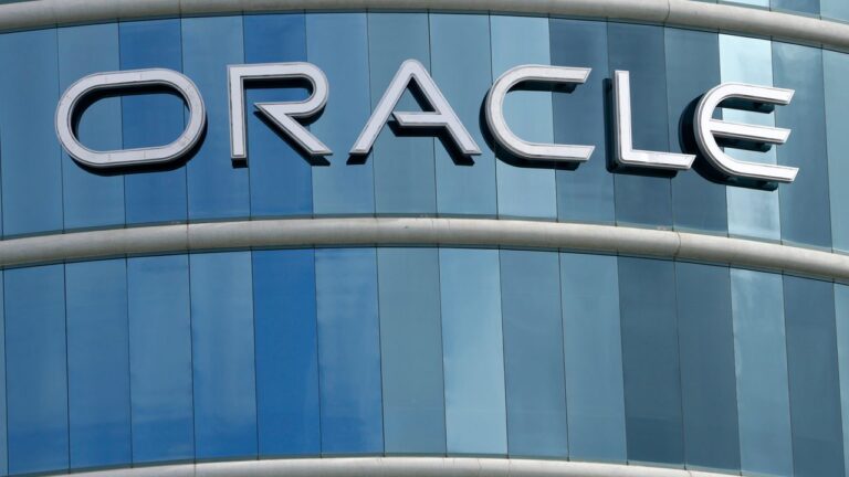 Logo-ul companiei Oracle pe fațada unei clădiri moderne cu geamuri albastre.