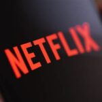 Logo-ul roșu al platformei Netflix afișat pe un ecran digital, reprezentând servicii de streaming video.