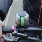 Clopot de bicicletă Skoda DuoBell montat pe ghidonul unei biciclete.