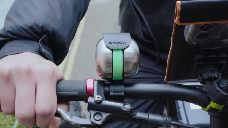 Clopot de bicicletă Skoda DuoBell montat pe ghidonul unei biciclete.
